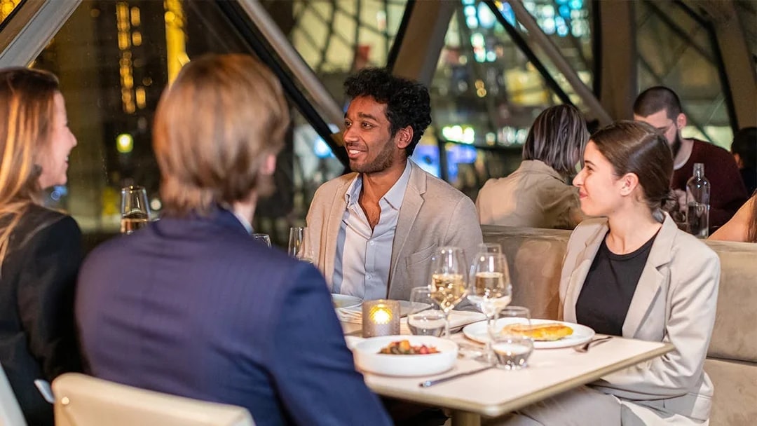 Dinner conversation at Madame Brasserie, Paris, with people enjoying a meal.