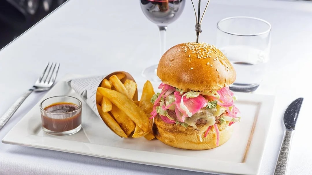 Burger and fries served at Le Bistro Parisien with a glass of red wine.