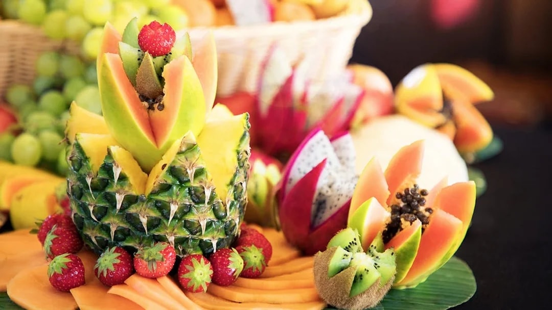 Fruit arrangement at Le Bistro Parisien dinner, featuring pineapple, papaya, and strawberries.
