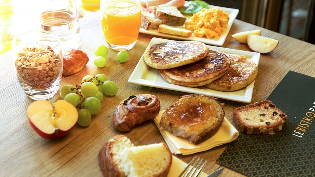 Assorted breakfast items at Le Bistro Parisien, Paris, with pancakes, fruit, and pastries.