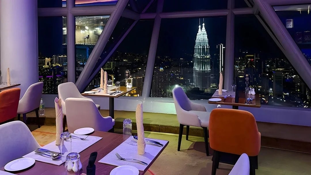 Dining tables with a view of Kuala Lumpur skyline from Orbit Revolving Restaurant in KL Tower.