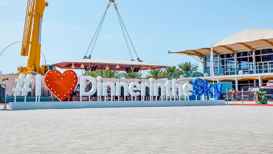 Dinner in the Sky sign with crane and dining platform in outdoor setting.