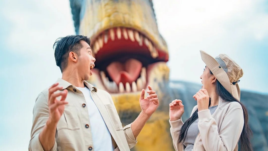 Visitors react to a large dinosaur sculpture at Dino Desert attraction.