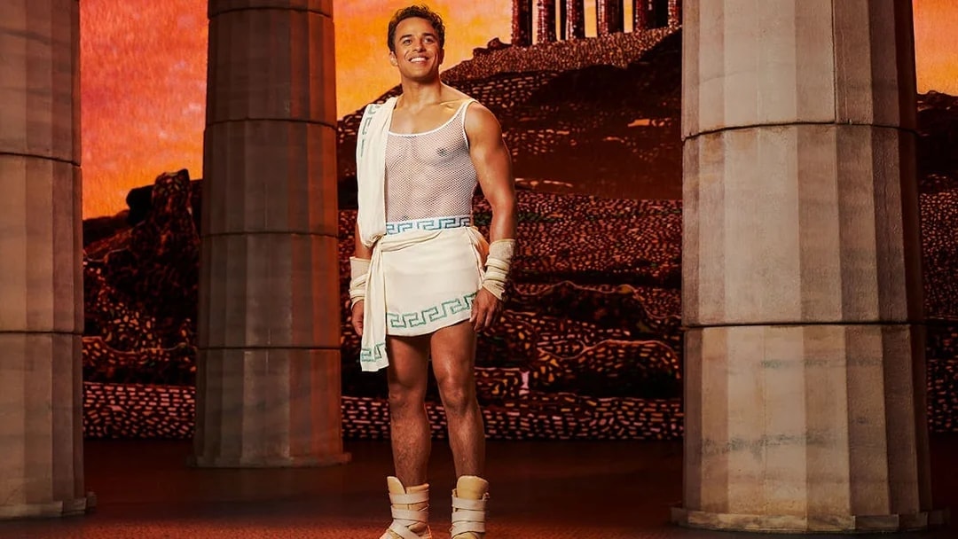 Man in ancient Greek attire stands between columns, representing Disney's Hercules.