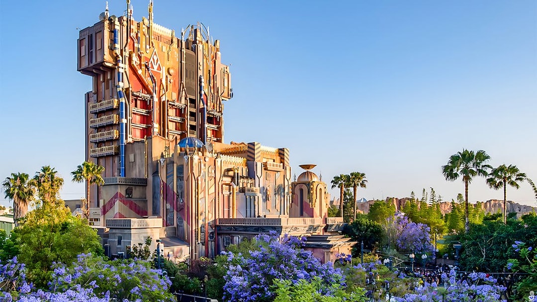 Guardians of the Galaxy attraction at Disneyland Adventure Park, California, surrounded by palm trees and flowers.