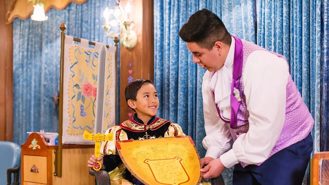 Child in knight costume holding shield at Disneyland Park, California.