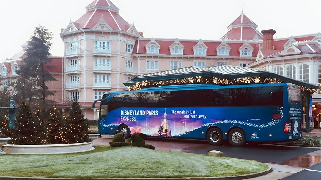 Disneyland Paris Express bus parked in front of a hotel, ready for round-trip to Paris.