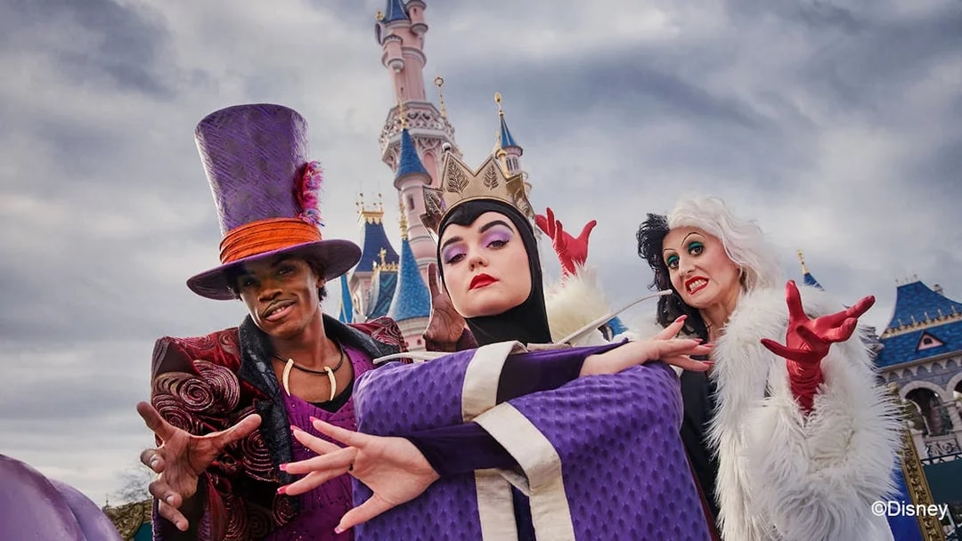 Disney villains posing in front of Sleeping Beauty Castle at Disneyland Paris during Halloween.
