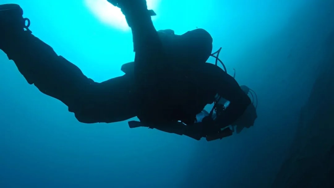 Certified diver exploring underwater in Aci Castello, Italy.