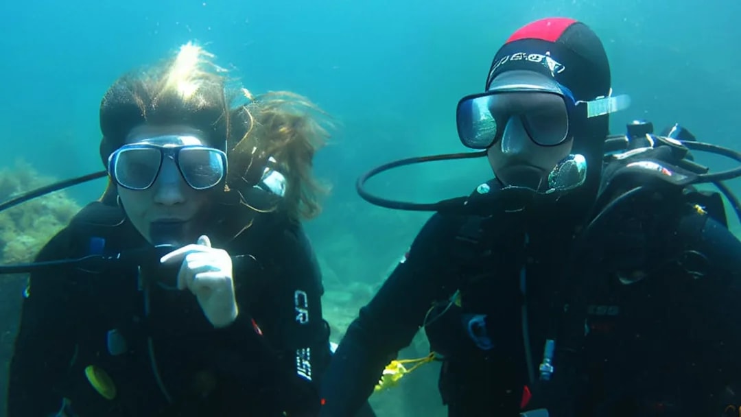 Certified divers exploring underwater in Aci Castello, Sicily.