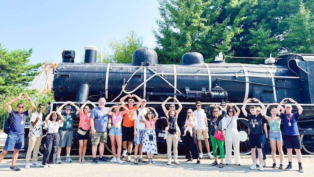 Tourists posing in front of Korean War steam locomotive at Imjingak Park on DMZ tour.