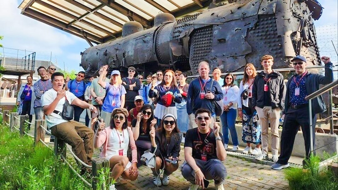 Tour group at bullet-riddled steam locomotive, Korean War relic, DMZ, South Korea.