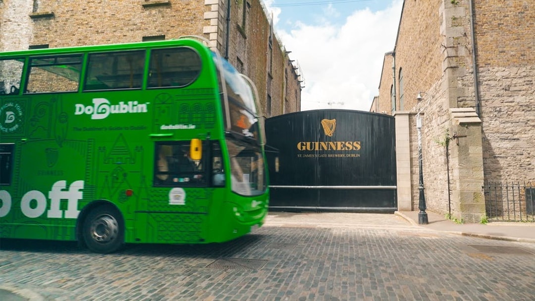 Dublin hop-on hop-off bus passing Guinness Storehouse entrance.