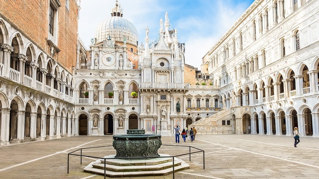 Doge's Palace courtyard with ornate architecture and central fountain in Venice, Italy.