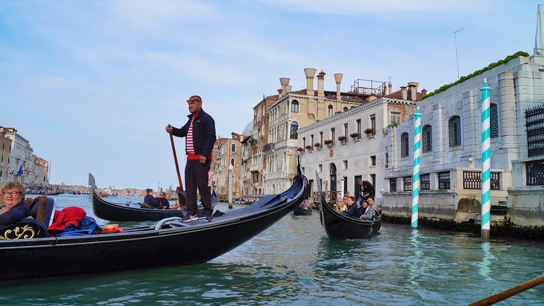 Gondola ride on Venice canal near historic buildings, Italy.