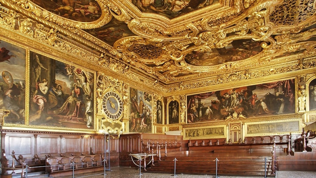 Doge's Palace ornate hall with gilded ceiling and historic paintings, Venice, Italy.