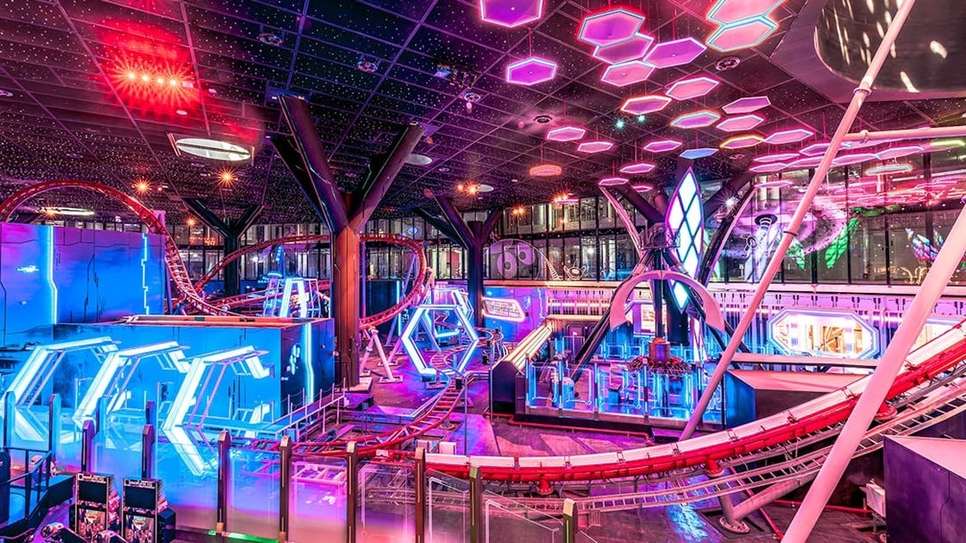 Roller coaster and neon lights inside Doha Quest Theme Park.