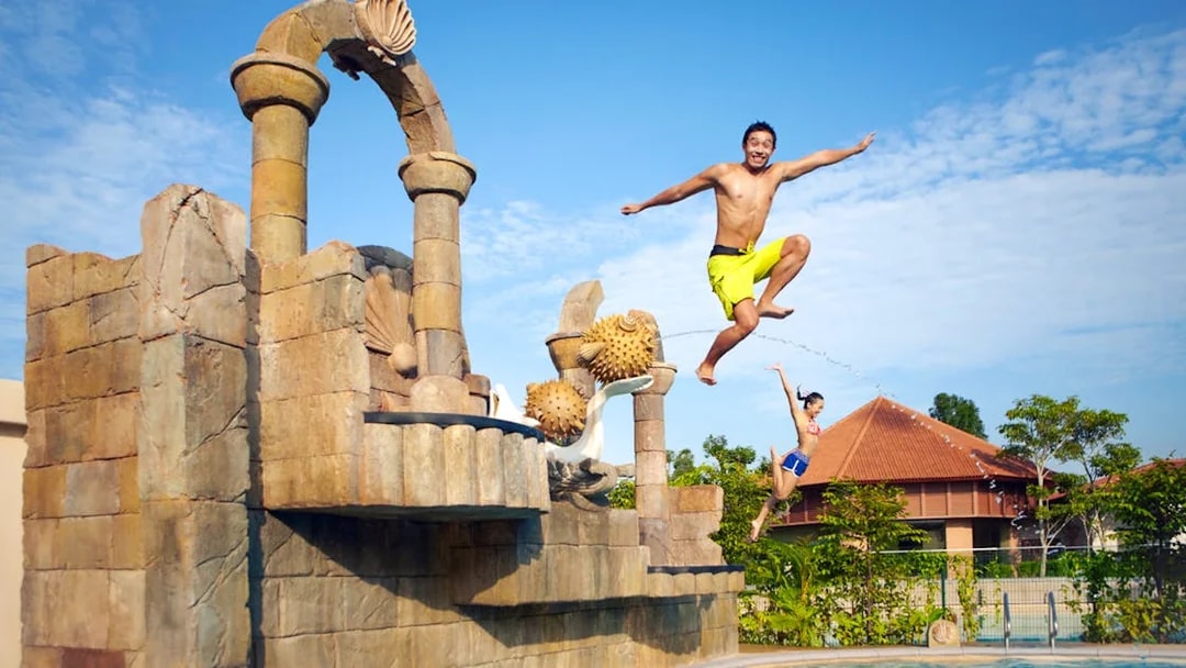 Visitors jumping into a pool at Adventure Cove Waterpark™‎, Singapore.