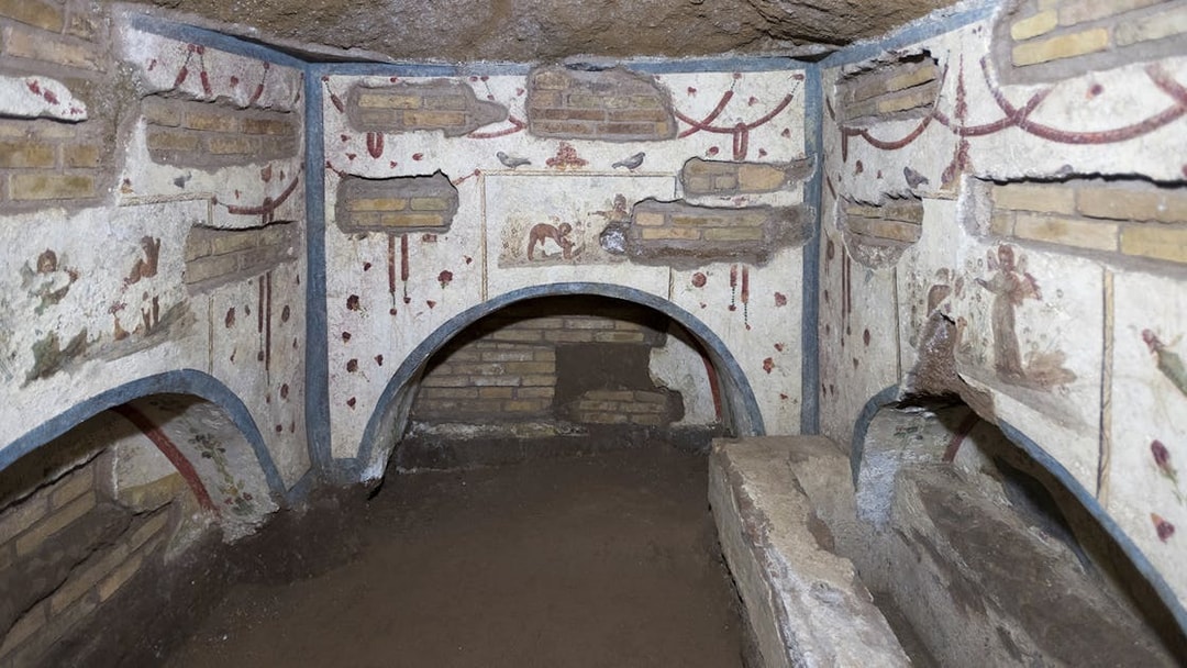 Catacombs of Domitilla in Rome with ancient frescoes and burial niches.