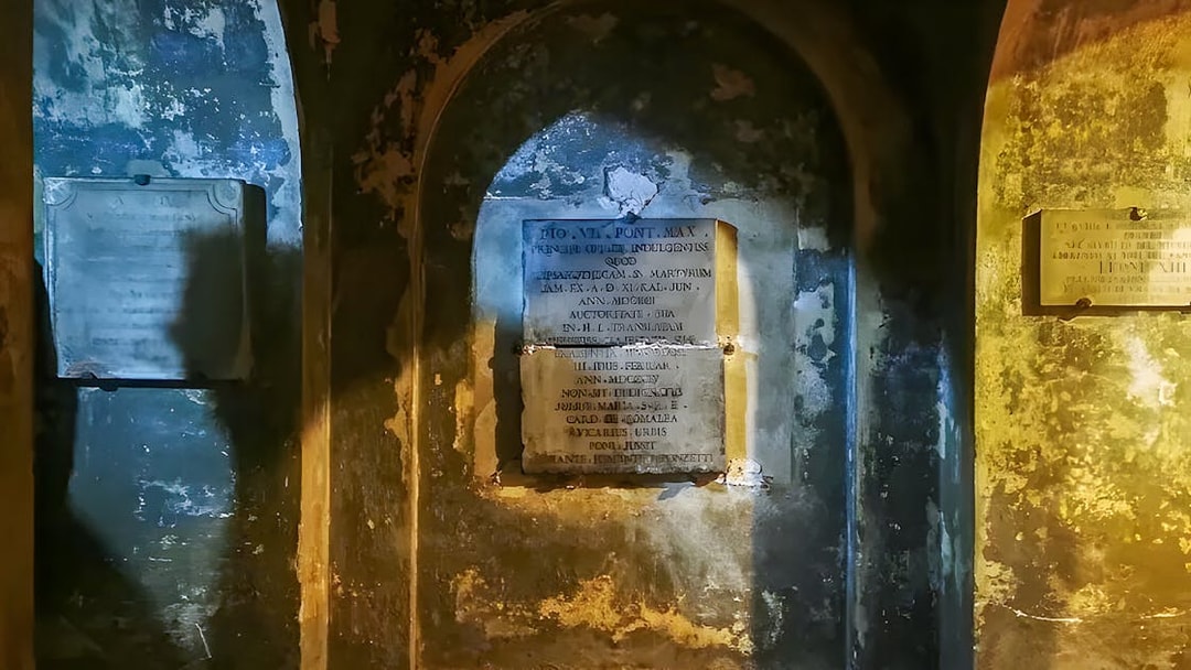 Ancient inscriptions on the walls of the Roman Catacombs during a guided tour from Rome.