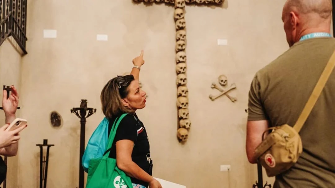 Tourists observing skull cross in Capuchin Crypts, Rome.