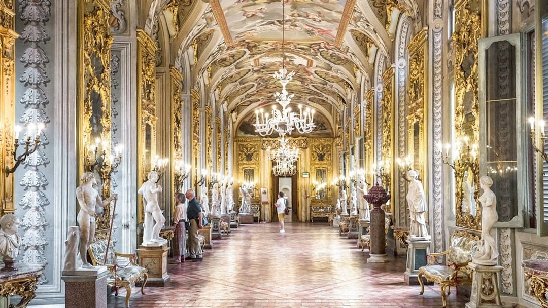 Doria Pamphilj Gallery hall with ornate ceiling, chandeliers, and classical statues in Rome.