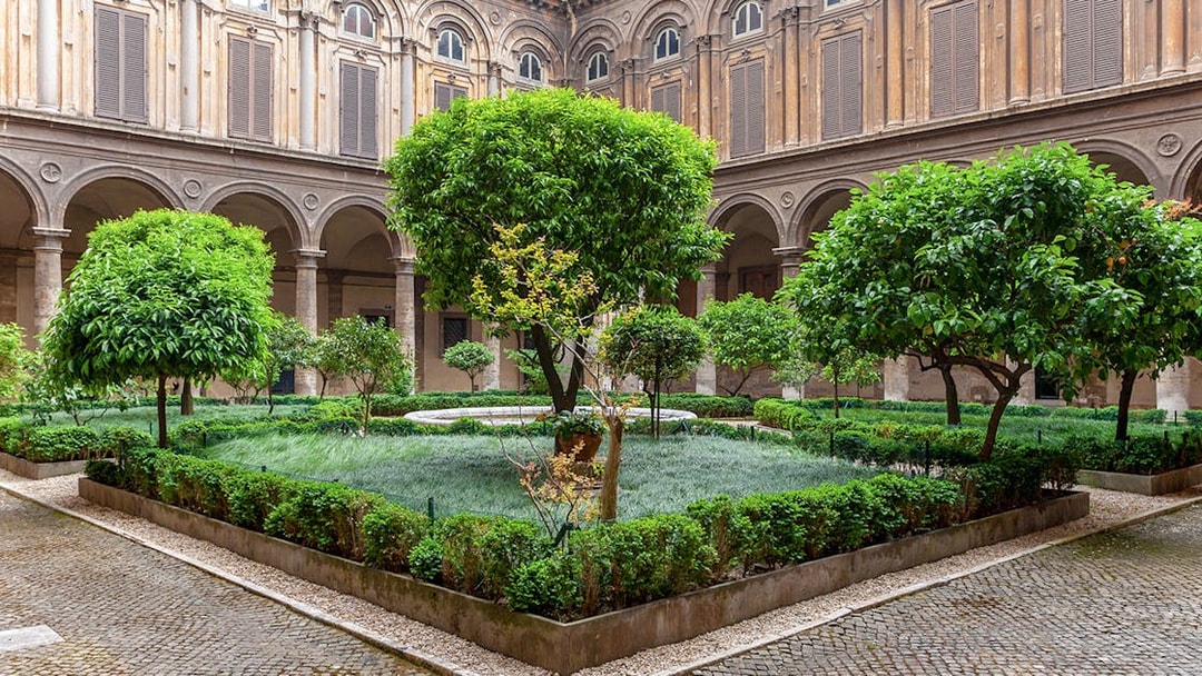 Doria Pamphilj Courtyard with lush greenery and historic architecture in Rome.