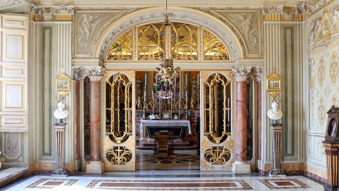 Doria Pamphilj Gallery ornate interior with gilded doors and marble columns.