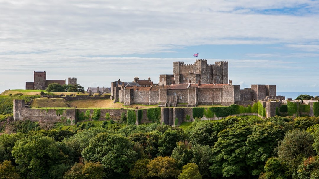 Dover Castle exterior with stone walls and lush greenery in Dover, England.