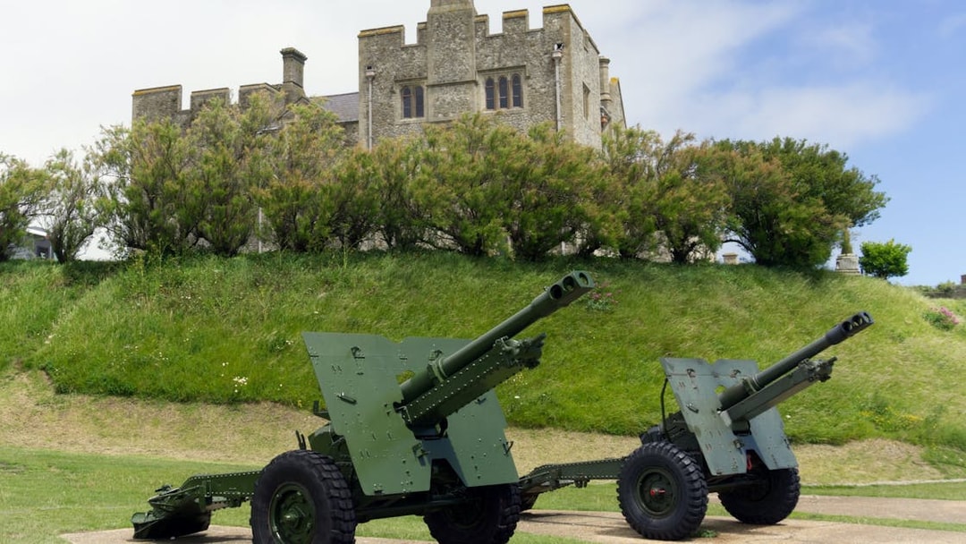 Cannons on display at Dover Castle, England, with historic stone structure in the background.