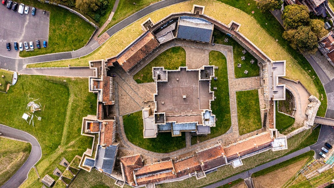 Aerial view of Dover Castle's medieval architecture and surrounding grounds in England.