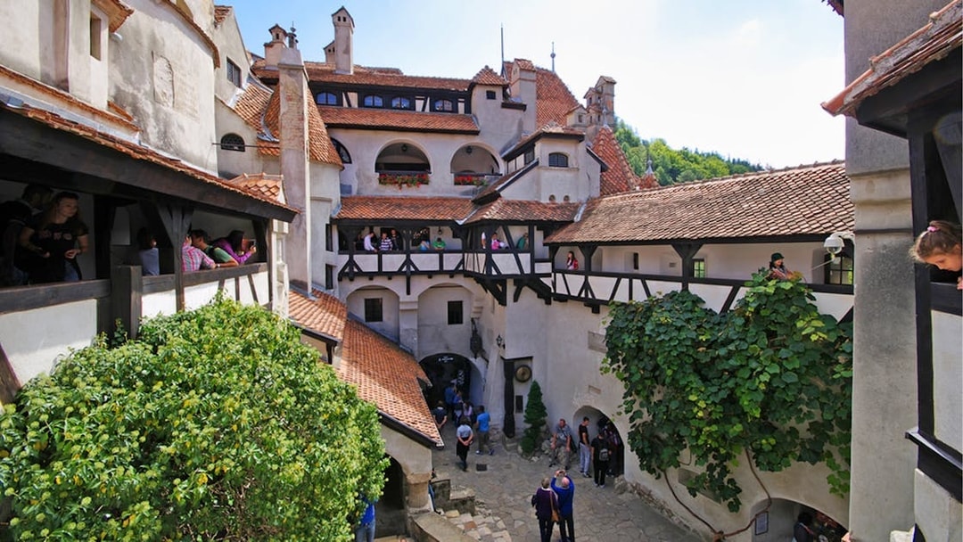 Bran Castle courtyard with tourists exploring Dracula's historical site in Romania.