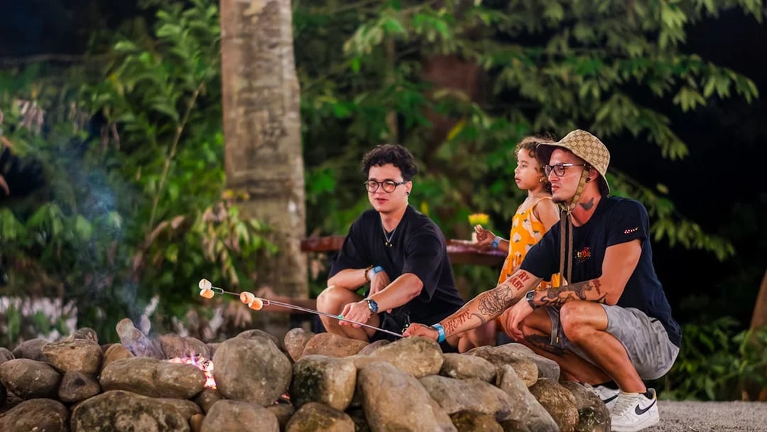 Tourists roasting marshmallows at a campfire in Dream Forest Langkawi.