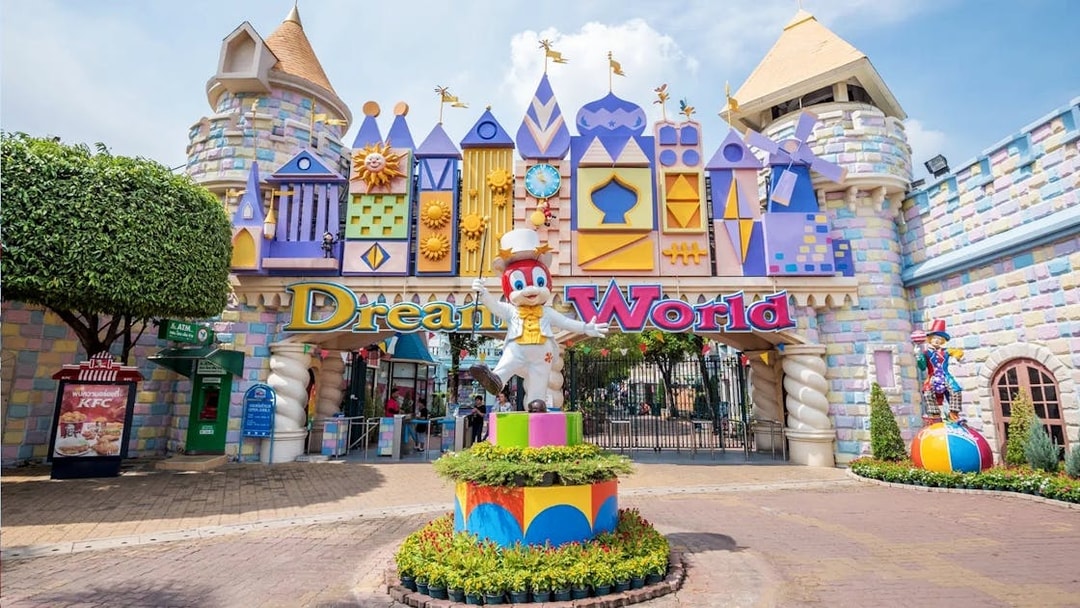 Dream World Bangkok entrance with colorful castle facade and character statue.
