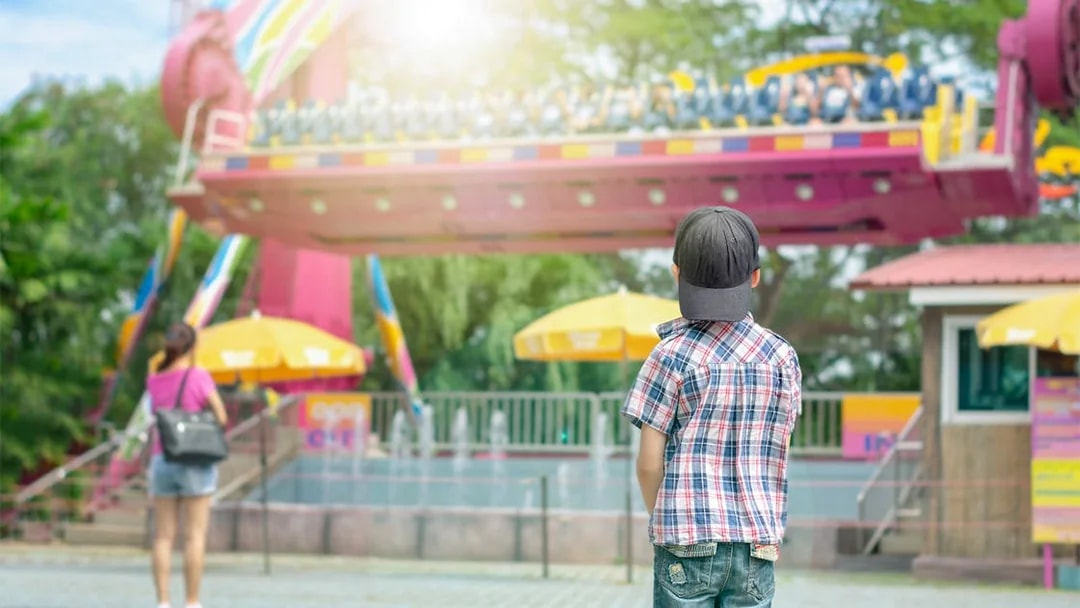 Child watching a ride at Dream World Bangkok amusement park.
