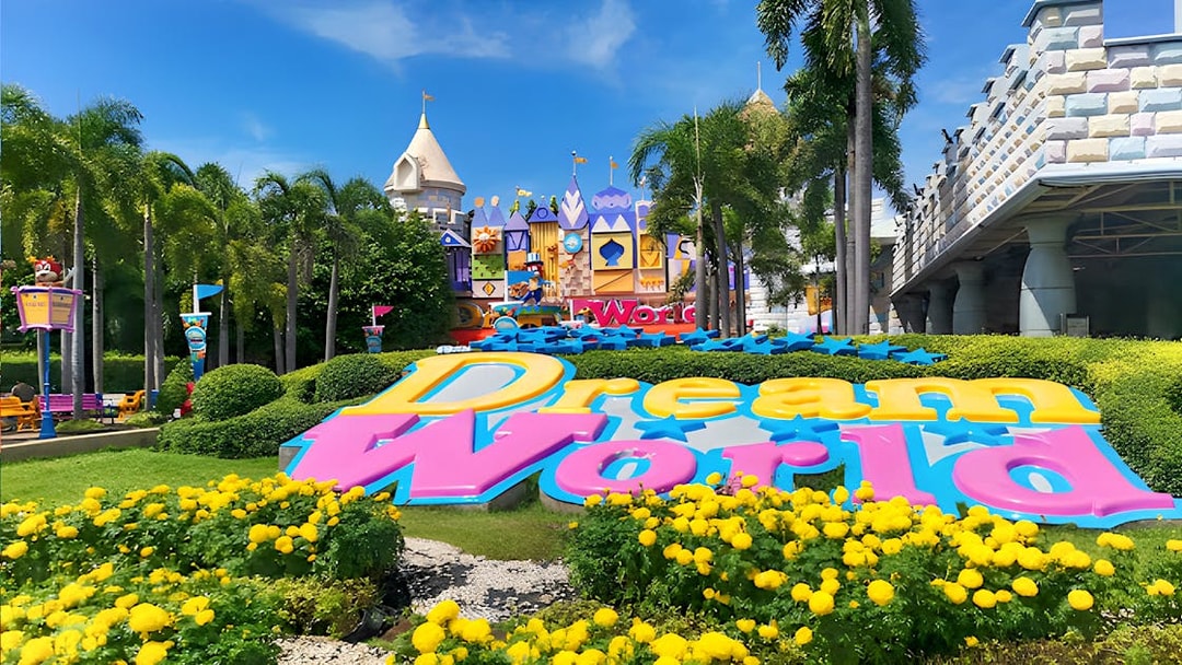 Dream World Bangkok entrance with colorful sign and vibrant gardens.