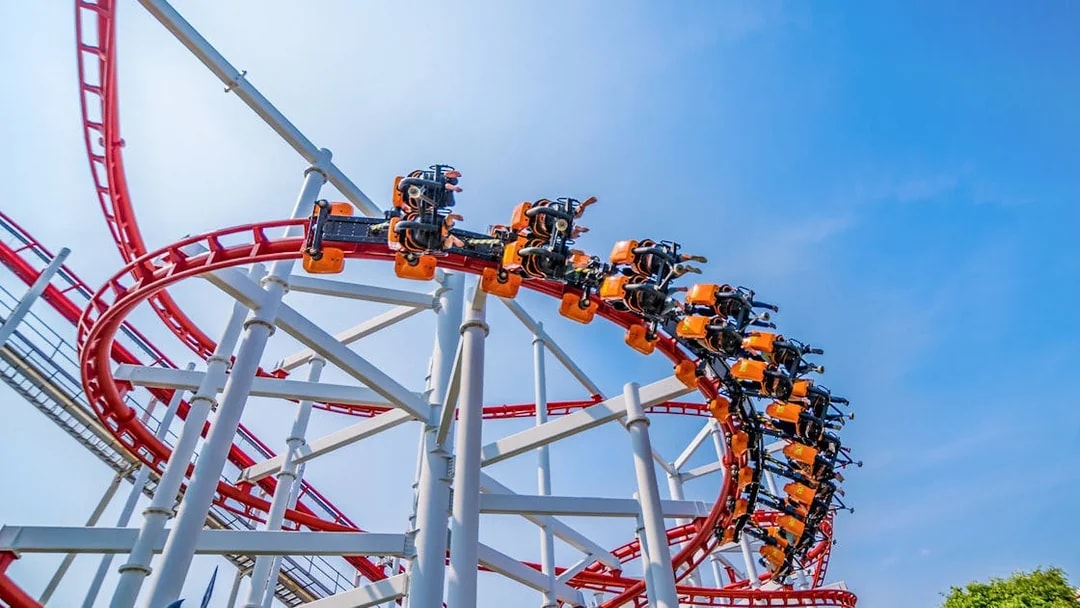 Roller coaster loop at Dream World Bangkok against blue sky.