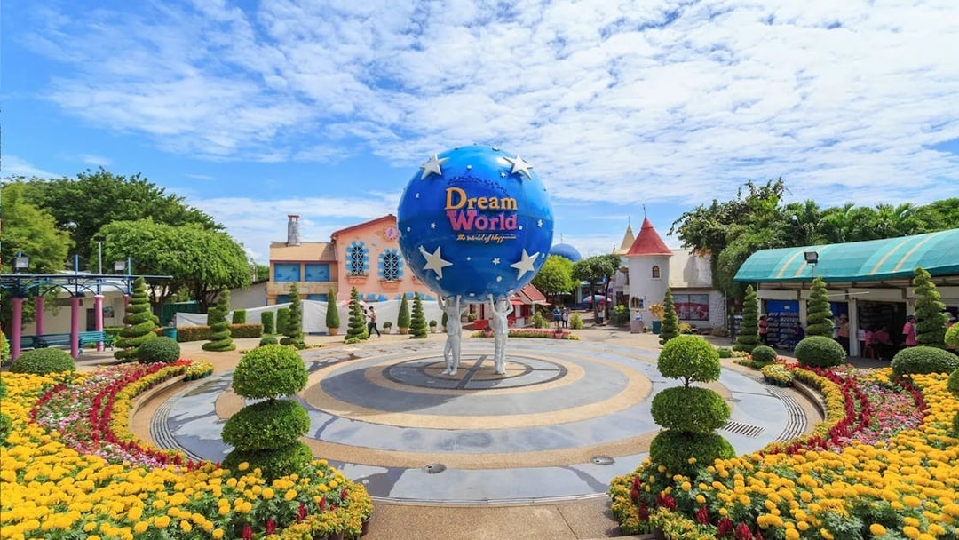 Dream World Bangkok entrance with globe sculpture and colorful gardens.