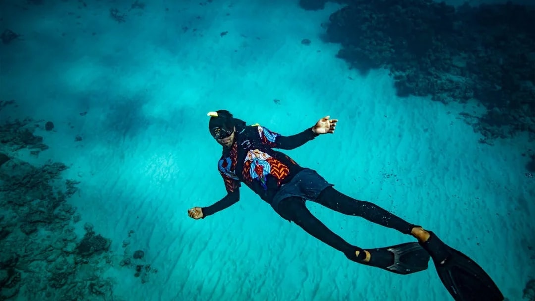 Snorkeler exploring vibrant coral reef during Dreamtime Dive & Snorkel Experience from Cairns.