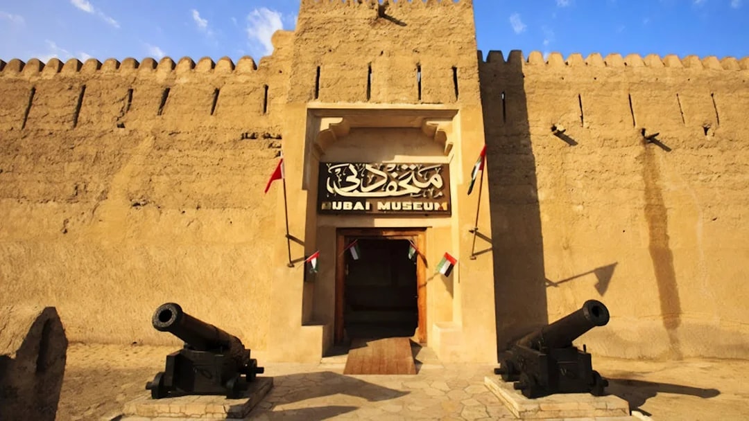 Dubai Museum entrance with cannons and flags, part of Snapshot Tour of Dubai.