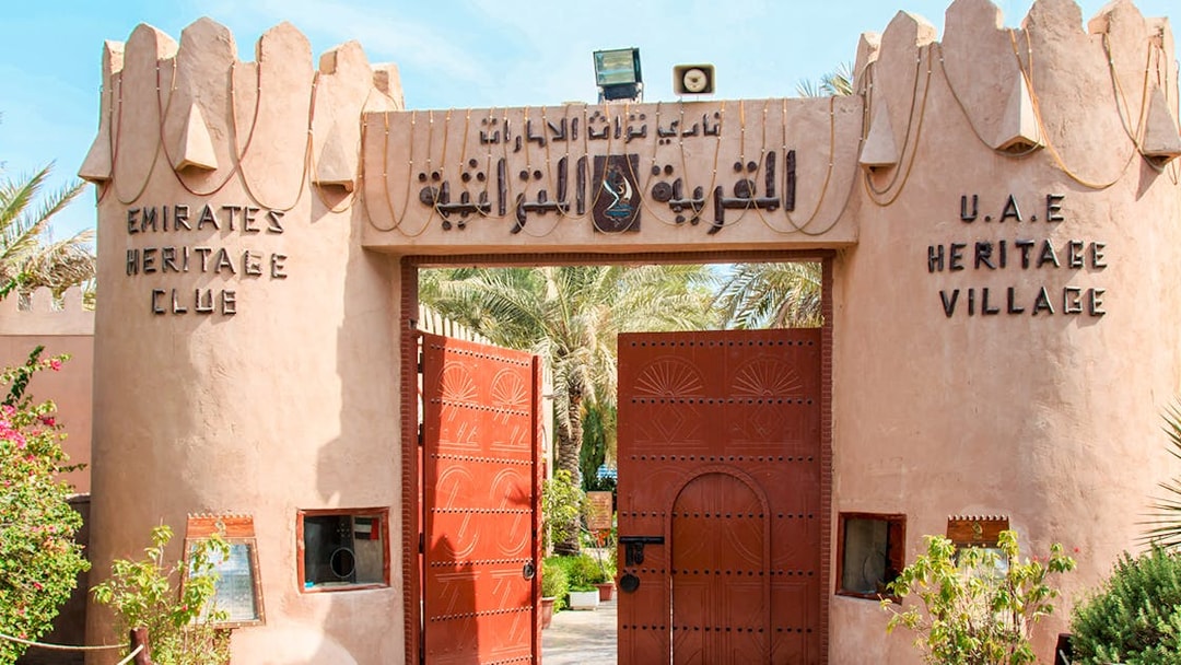 Heritage Village entrance with open wooden gates in Abu Dhabi.