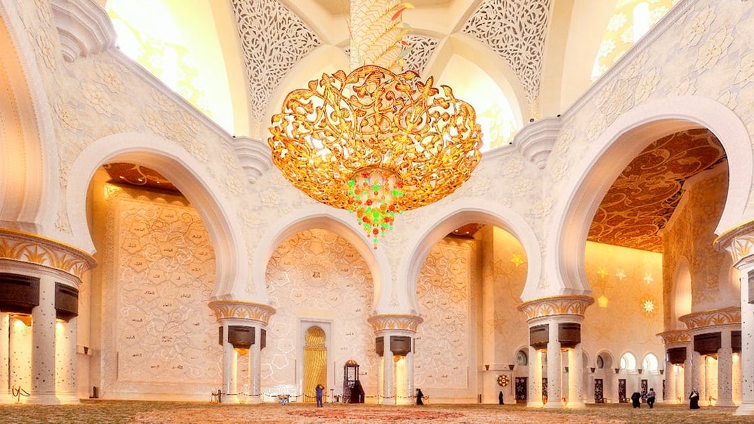 Sheikh Zayed Mosque interior with ornate chandelier and intricate wall designs, Abu Dhabi tour.