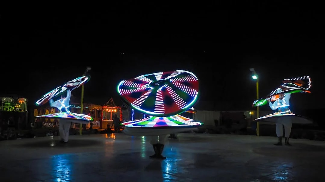 Tanoura dancers performing with illuminated skirts in Dubai.