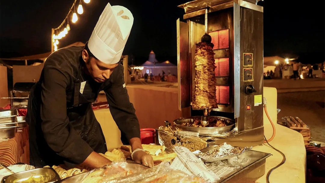 Chef preparing shawarma at a Dubai desert safari event.