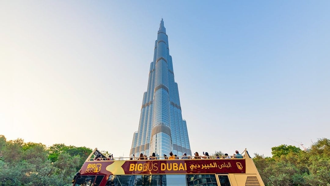Open-top Big Bus tour in Dubai with Burj Khalifa in the background.