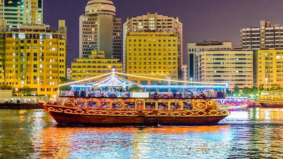 Dhow boat cruising Dubai Marina with city skyline, part of Big Bus Dubai tour.