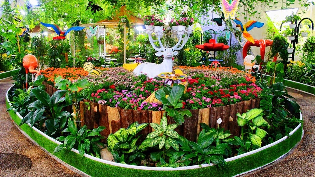 Visitors exploring vibrant flora and butterfly sculptures at Dubai Butterfly Garden.