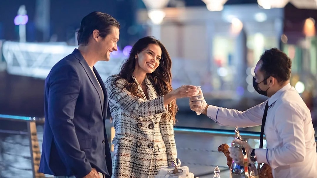 Couple greeted with drinks on the Luxury Dhow Cruise deck at night.