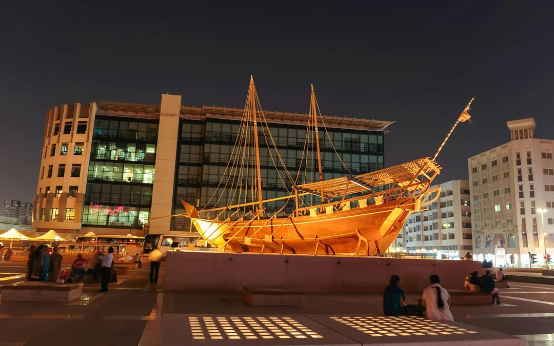 Wooden dhow boat displayed at night near Al Fahidi Fort, Dubai.