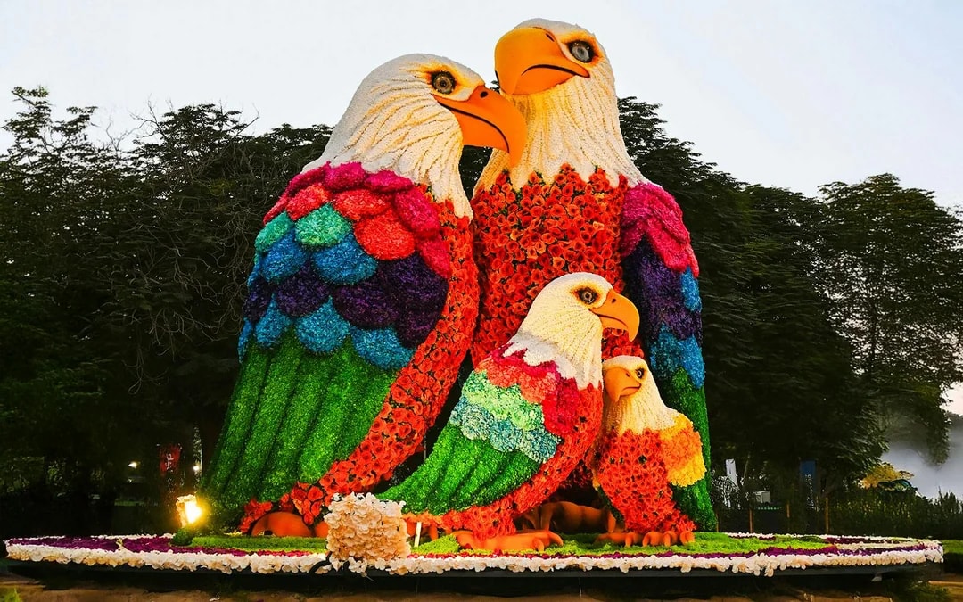Floral eagle sculptures at Dubai Garden Glow with Dubai Frame in the background.